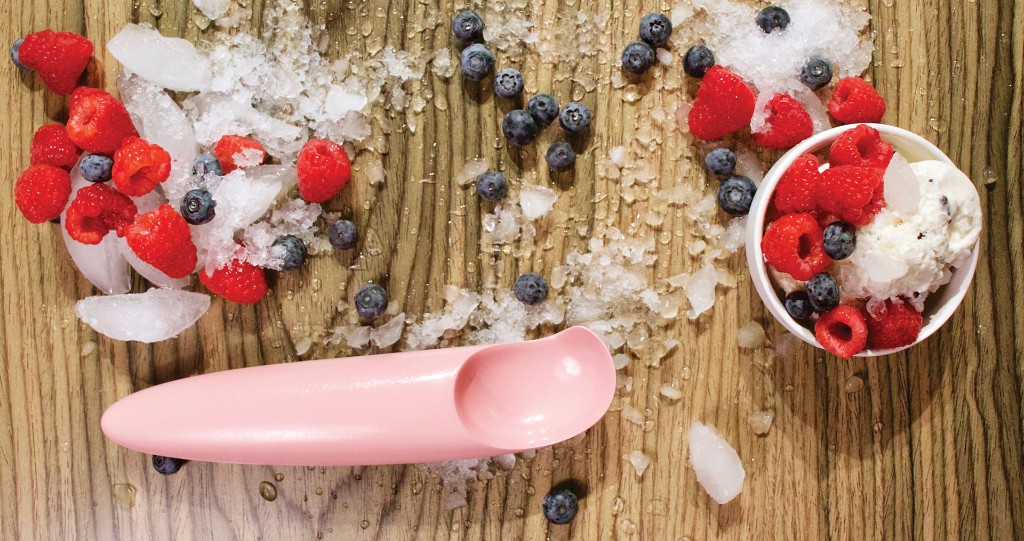 Top-down lifestyle photo of Scoopi with ice cream, berries, and crushed ice on wood